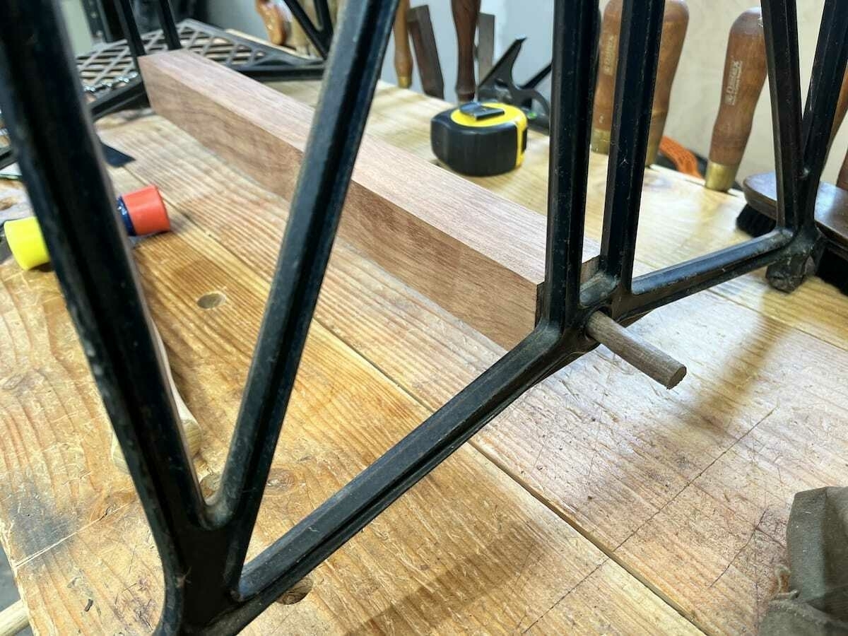 dowels inserted through cast iron frame into bubinga, long end