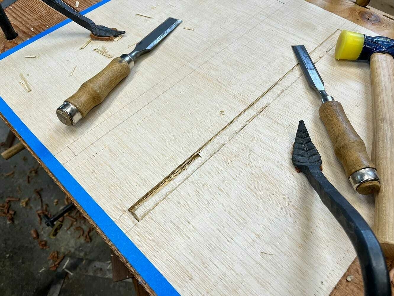 Chiseling out holes in plywood panel, which ultimately failed.